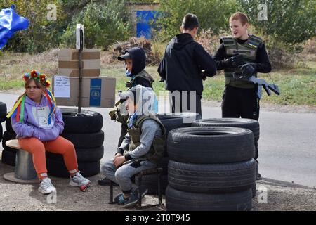 Bilenke, Ukraine. Oktober 2023. Kinder, die vorgeben, territoriale Verteidigungskämpfer zu sein, kontrollieren den Verkehr an ihrem Spielkontrollpunkt im Dorf Bilenke in der Region Zaporischzhia. Alle ukrainischen Kinder sind tief vom Krieg betroffen. Viele haben ihr Leben radikal verändert, weil sie ihre Häuser verloren haben oder gezwungen wurden, zu evakuieren. (Foto: Andriy Andriyenko/SOPA Images/SIPA USA) Credit: SIPA USA/Alamy Live News Stockfoto