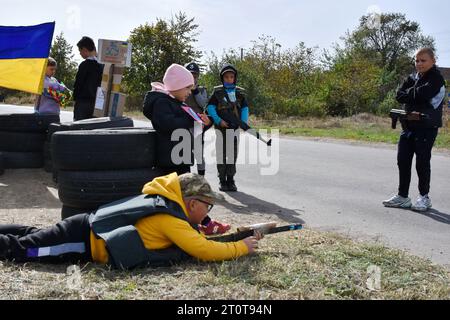 Bilenke, Ukraine. Oktober 2023. Kinder, die vorgeben, territoriale Verteidigungskämpfer zu sein, werden an ihrem Spielkontrollpunkt im Dorf Bilenke in der Region Zaporischschhia gesehen. Alle ukrainischen Kinder sind tief vom Krieg betroffen. Viele haben ihr Leben radikal verändert, weil sie ihre Häuser verloren haben oder gezwungen wurden, zu evakuieren. (Foto: Andriy Andriyenko/SOPA Images/SIPA USA) Credit: SIPA USA/Alamy Live News Stockfoto