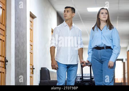 Junges Paar, das zu einem reservierten Zimmer in einem Luxushotel ging Stockfoto