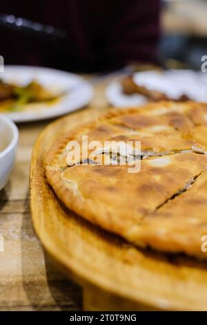 Goshnan, oder Gosh-Naan, ein traditioneller uigurischer Kuchen gefüllt mit gewürztem Hackfleisch (Rindfleisch und Lamm) und Zwiebeln im Apandim Uyghur Restaurant in Sydney Stockfoto