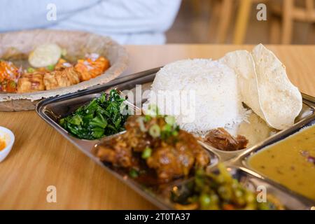 Chicken Daal Baht Power (Reis, Spinat, Linsen, Gurke & Hühnercurry) serviert auf einem Edelstahltablett in einem nepalesischen Restaurant in Sydney Stockfoto