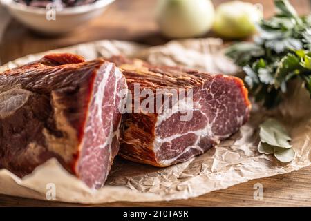 Geräucherter Schweinehals, in zwei Teile geschnitten, bereit für die Wärmebehandlung. Stockfoto