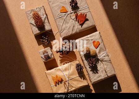 Keine verschwenderische Weihnachts-Knolling-Wohnung mit harten Schatten. Handgefertigtes Öko-Geschenk, natürliche Silvester-Jute-Dekoration, Draufsicht. Kraftpapier verpackt mit Stockfoto