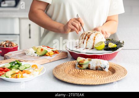Eine Frau bereitet Frühlingsbrötchen mit Reis und Gemüse zu. Stockfoto