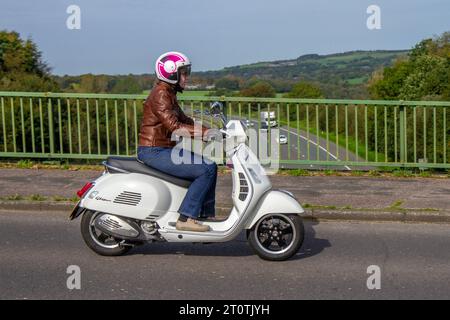 2018 Frau reitet weiß Italienisch Piaggio Vespa GTS 300 Super ABS Roller 4-Ventil, Viertakt, Einzylinder, elektronische Einspritzung, katalysiertes Fahrzeug über die Autobahnbrücke in Manchester, Großbritannien Stockfoto