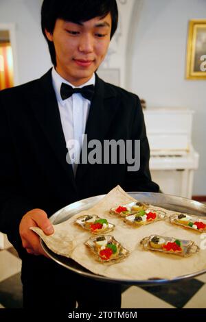 Kellner mit einem Teller mit rotem Kaviar im Russischen Reich, das als das exquisiteste Restaurant Russlands gilt, St.. Petersburg, Russland. Stockfoto