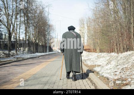 Rentner geht die Straße hinunter. Ältere Frau auf der Straße. Gehen Sie in den Park. Stockfoto