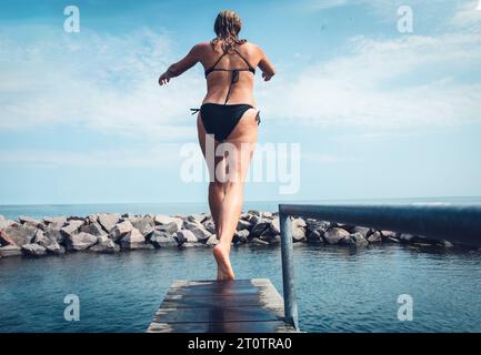 Frau, die Mit Einem Tauchbrett in Skandinavien ins Meer geht Stockfoto