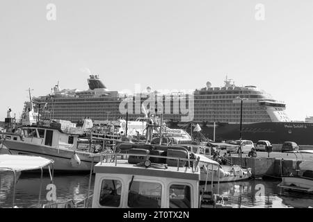 Mein Schiff 6, ein Kreuzfahrtschiff von TUI Cruises, legte in Schwarz-weiß am belebten Hafen von Rhodos in Griechenland an Stockfoto