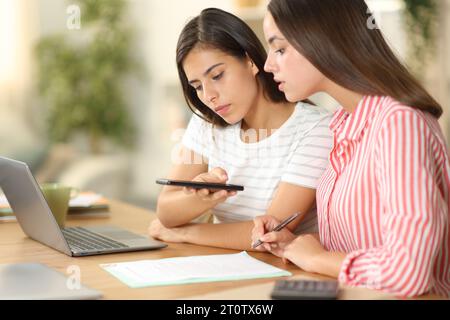 Frauen, die einen Vertrag fotografieren und online arbeiten zu Hause Stockfoto