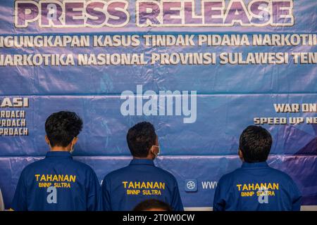 Kendari, Indonesien. Oktober 2023. Drei Verdächtige stehen, während Offiziere eine Pressekonferenz im Southeast Sulawesi BNN Büro abhalten. Der Nationalen Suchtstoffbehörde (BNN) der Provinz Südosten Sulawesi gelang es, drei Verdächtige im Falle des Schmuggels von Methamphetamin mit einem Gewicht von 1 Kilo, 500 Gramm und 10 Gramm an zwei verschiedenen Orten festzunehmen. Quelle: SOPA Images Limited/Alamy Live News Stockfoto