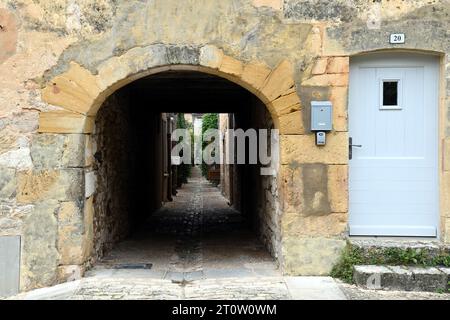 Eine Gasse in die Mauern der bastide-Stadt Monpazier in der französischen Dordogne. Die Stadt ist ein beliebtes Touristenziel. Stockfoto