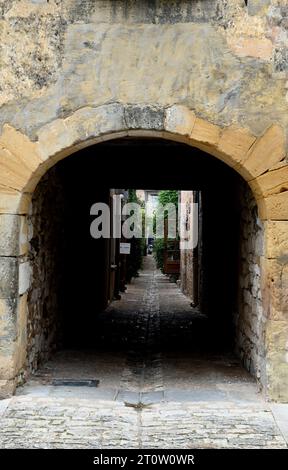 Eine Gasse in die Mauern der bastide-Stadt Monpazier in der französischen Dordogne. Die Stadt ist ein beliebtes Touristenziel. Stockfoto