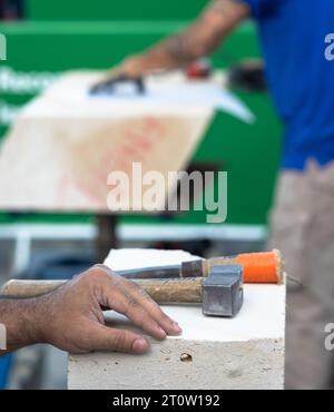 Ein französischer Steinmetze legt seine Hand neben Hammer und Meißel, während er an der Renovierung der Kathedrale Notre Dame in Paris, Frankreich, arbeitet. Die Antike Stockfoto
