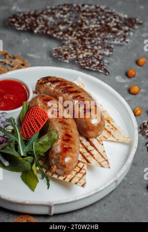 Gegrillte leckere Bratwurst-Würste auf dem Teller Stockfoto