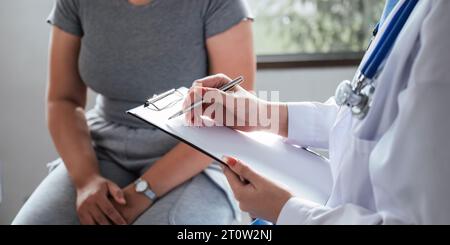 Übergewichtige, fette Frau, die im Büro beraten wird. Porträt eines freundlich lächelnden Arztes, der Hand auf Schulter hält, den Patienten unterstützt, gibt Stockfoto