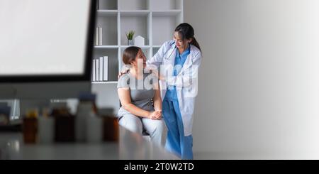 Übergewichtige, fette Frau, die im Büro beraten wird. Porträt eines freundlich lächelnden Arztes, der Hand auf Schulter hält, den Patienten unterstützt, gibt Stockfoto