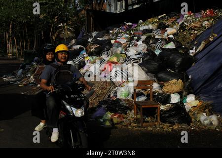 9. Oktober 2023, Yogyakarta, Spezialregion Yogyakarta, Indonesien: Motorradfahrer fahren in der Nähe von Müllhaufen in Yogyakarta vorbei. (Kreditbild: © Angga Budhiyanto/ZUMA Press Wire) NUR REDAKTIONELLE VERWENDUNG! Nicht für kommerzielle ZWECKE! Stockfoto