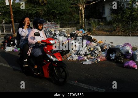 9. Oktober 2023, Yogyakarta, Spezialregion Yogyakarta, Indonesien: Motorradfahrer fahren in der Nähe von Müllhaufen in Yogyakarta vorbei. (Kreditbild: © Angga Budhiyanto/ZUMA Press Wire) NUR REDAKTIONELLE VERWENDUNG! Nicht für kommerzielle ZWECKE! Stockfoto