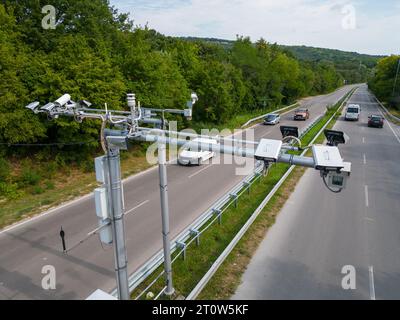 Kameras und Radargeräte zur Geschwindigkeitskontrolle entlang einer stark frequentierten Autobahn überwachen und erfassen Geschwindigkeitsverstöße. Stockfoto
