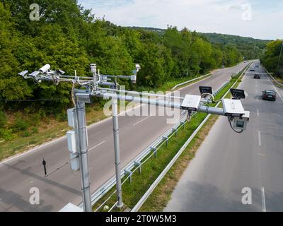 Kameras und Radargeräte zur Geschwindigkeitskontrolle entlang einer stark frequentierten Autobahn überwachen und erfassen Geschwindigkeitsverstöße. Stockfoto