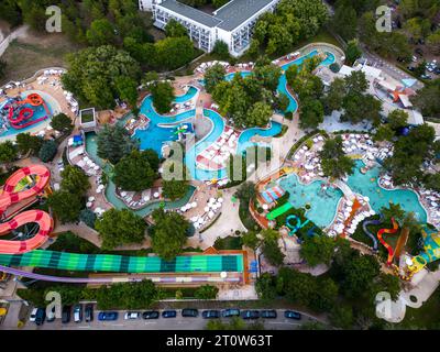 Aus der Vogelperspektive sehen Sie eine lebhafte Szene eines Aquaparks, wo die Menschen Rutschen und Pools genießen. Lachen und Freude erfüllen die Luft. Stockfoto