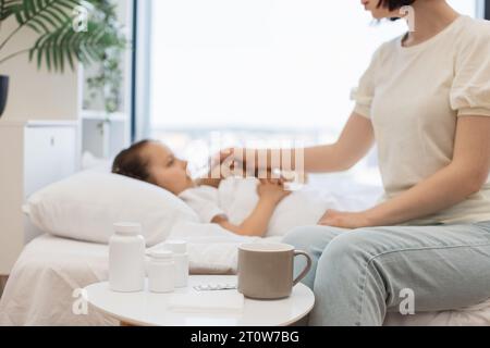 Mutter benutzt medizinische Vorräte auf dem Tisch für die Pflege kranker Kinder Stockfoto