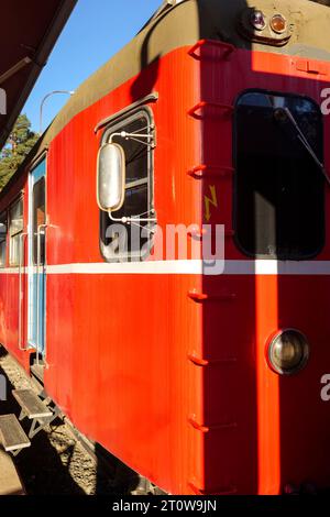 Rote Oldtimer-Lokomotive auf einem Bahnhof stationiert. Stockfoto