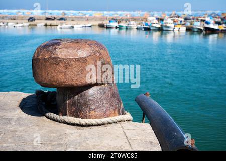Rostiger alter Stahlanker mit Meer- und Fischerboothintergrund. Stockfoto