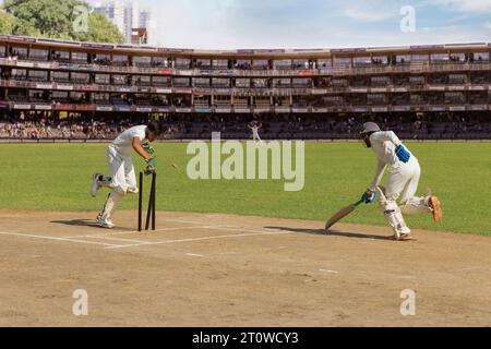 Batsman läuft, als der Wicket Keeper versucht, ihn während eines Cricketspiels auszuschalten Stockfoto