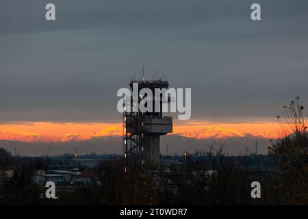 Triest, Italien - 15. Dezember 2022: Flughafenkontrollturm am Flughafen Ronchi dei Legionari Triest bei farbenfrohem Sonnenuntergang über der Stadt, Italien Stockfoto