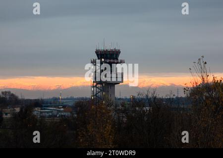 Triest, Italien - 15. Dezember 2022: Flughafenkontrollturm am Flughafen Ronchi dei Legionari Triest bei farbenfrohem Sonnenuntergang über der Stadt, Italien Stockfoto