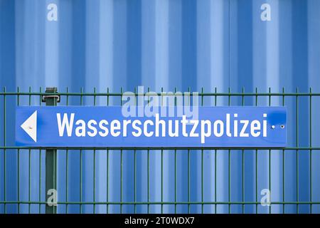 Schild mit dem deutschen Wort Wasserschutzpolizei, was Wasserschutzpolizei bedeutet, auf einem Zaun vor einer blauen Mauer, Kopierraum, ausgewählter Fokus Stockfoto