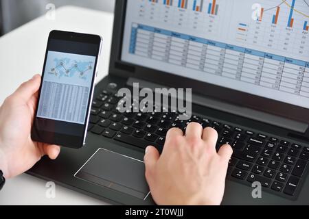 Geschäftsleute, die Ihr Smartphone verwenden, analysieren Geschäftsstatistiken mit Diagrammen und Diagrammen. Erfolg und Startup-Konzept. Stockfoto