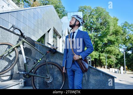 Bärtiger Geschäftsmann mit digitalem Tablet in der Nähe des Business Centers. Verkehrskonzept für Wirtschaft und Umwelt. Stockfoto