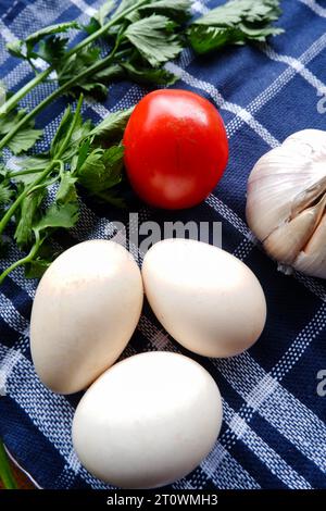 Das Foto ist ein Foto von verschiedenen Zutaten wie Eiern, Tomaten, Knoblauch und Sellerieblättern Stockfoto