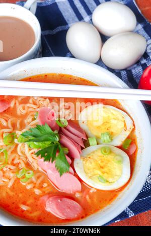 Foto von Nudelsuppe mit Belägen wie Würstchen, Eiern und Gemüse Stockfoto