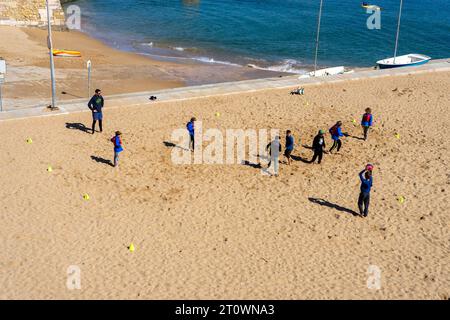 LAGOS, PORTUGAL - FERBUARY 28, 2023: Schüler spielen am 28. Februar 2023 Fußball an einem Strand in Lagos, Portugal Stockfoto