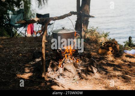 Touristische Topf über dem Feuer auf einem Stativ. Kochen in der Kampagne. Stockfoto