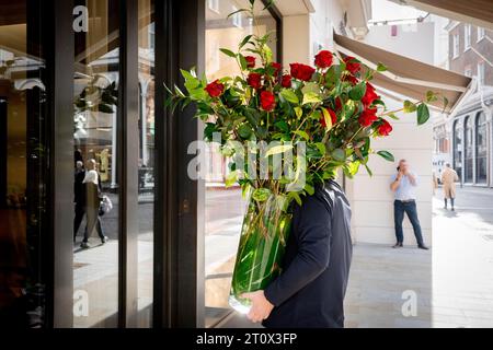 Ein großer Haufen wunderschöner roter Rosen wird am 9. Oktober 2023 in London an ein Unternehmen in der Bond Street geliefert. Stockfoto