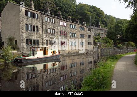 Traditionelle Reihenhütten und Boot neben dem Rochdale Canal an der Hebden Bridge West Yorkshire England Stockfoto