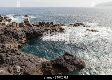 Porto do Seixal Wellenbrecher und Küstenfelsen. Sommerlandschaft der Insel Madeira, Portugal Stockfoto