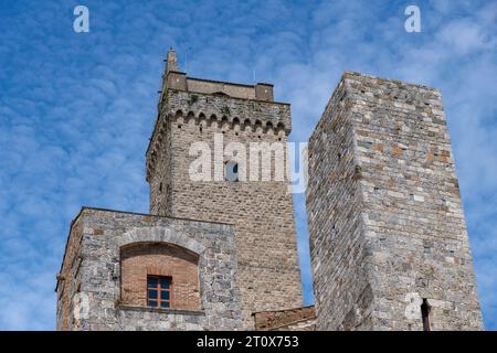 Niedriger Blick auf einige der Türme in San Gimignano, Italien, einer kleinen ummauerten mittelalterlichen Bergstadt in der Provinz Siena, Toskana vor einem weißen Clo Stockfoto