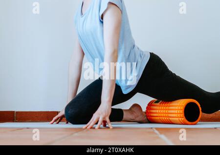 Quadrizeps-Selbstmyofaszienfreisetzung mit Schaumwalze Stockfoto