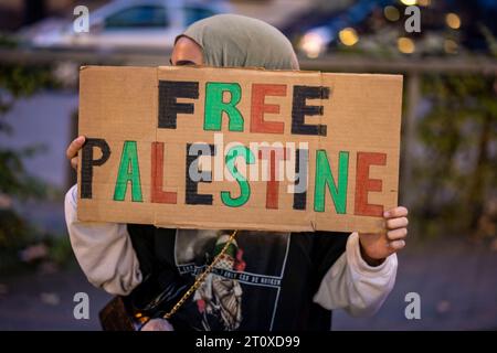 Duisburg, Deutschland. Oktober 2023. Eine Frau hält während einer pro-palästinensischen Kundgebung auf dem Brückenplatz ein Schild mit der Aufschrift "Free Palestine". Quelle: Christoph Reichwein/dpa/Alamy Live News Stockfoto