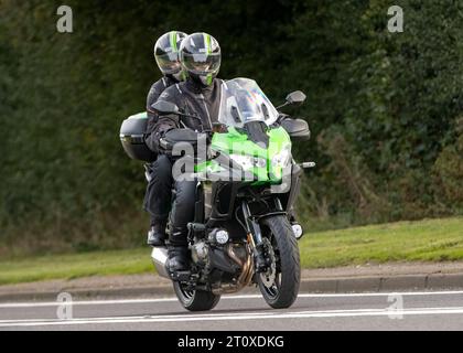 Bicester,Oxon.,UK - 8. Oktober 2023: 2022 Kawasaki KLZ 1000 CNSNN Motorrad mit Fahrer und Sozius auf einer englischen Landstraße. Stockfoto