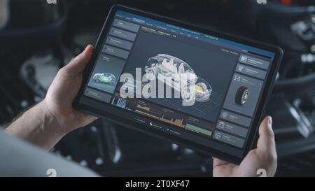 Männlicher Techniker hält einen digitalen Tablet-Computer. Simulation von Autodiagnosen und Aerodynamiktests in Echtzeit auf dem Bildschirm. 3D-Animation der Software mit virtuellem 3D-Elektrofahrzeugmodell. Stockfoto