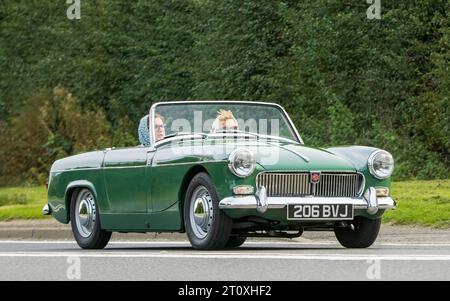 Bicester,Oxon.,UK - 8. Oktober 2023: 1962 Green Open Top MG Midget Oldtimer fährt auf einer englischen Landstraße. Stockfoto