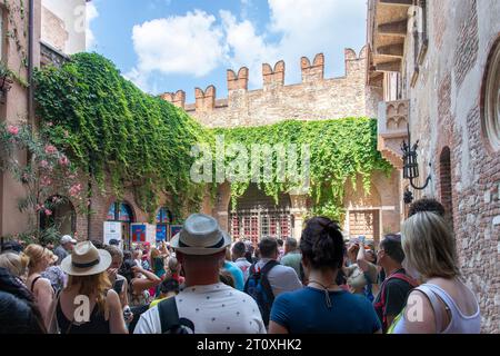 Verona, Italien, 12. Juni 2023; Innenhof voller Touristen vor dem Steinbalkon von Julias Haus im gotischen Stil, angeblich inspiriert Wilhelm Stockfoto