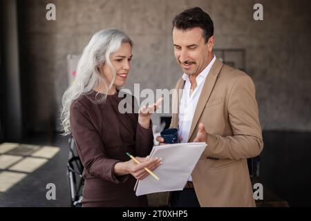 Zwei Geschäftskollegen Mittleren Alters Diskutieren Im Büro Über Projektdokumentation Stockfoto